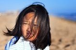 An Australian beach scene with a model wearing elegant black hair accessories, wind tousling her hair.