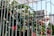 A close-up of a durable metal fence with a vibrant flower bed in the foreground.