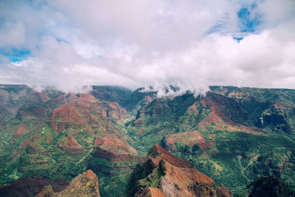 green and brown mountain under white clouds during daytime