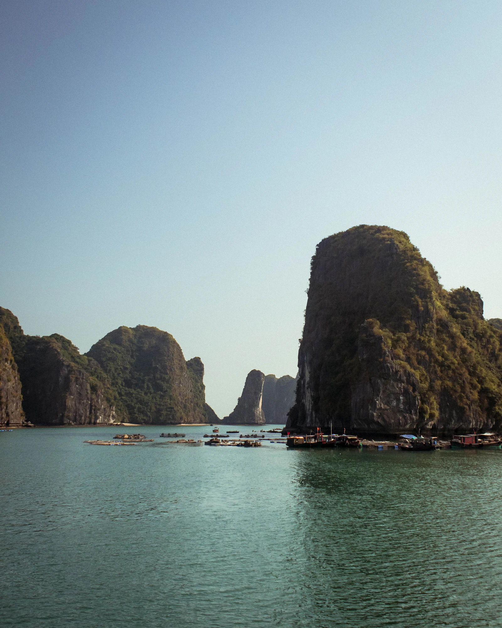 Tour boats moving through the karst formations of Ha Long Bay