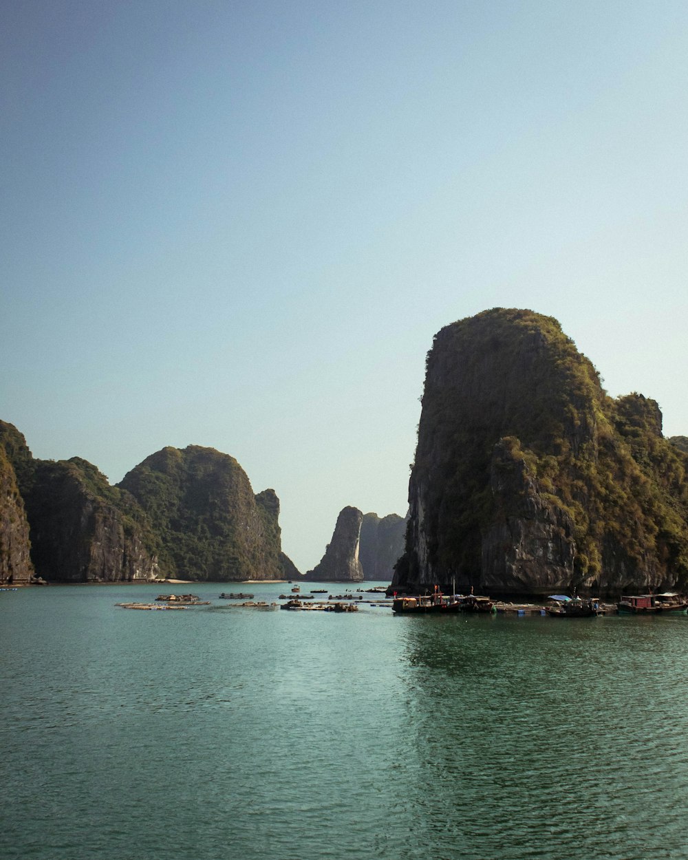 boats on sea near rock formation during daytime