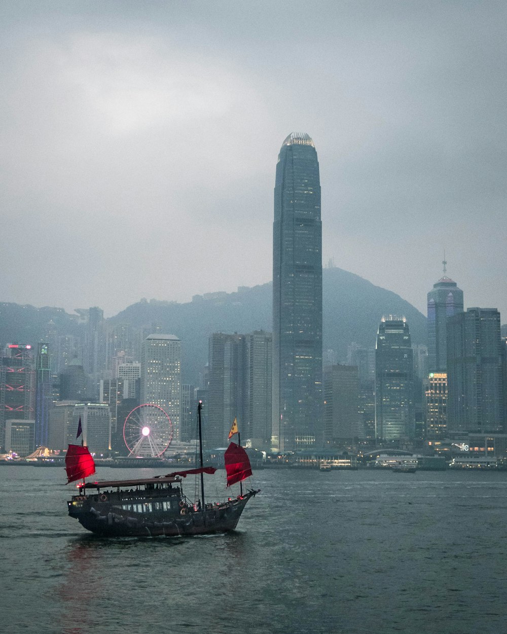 people riding on boat on water near city buildings during daytime