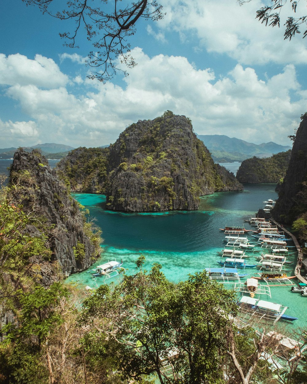 green and brown mountain beside body of water under blue sky during daytime