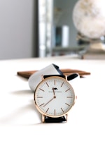 Elegant wrist adorned with a minimalist gold watch against a clean white background.