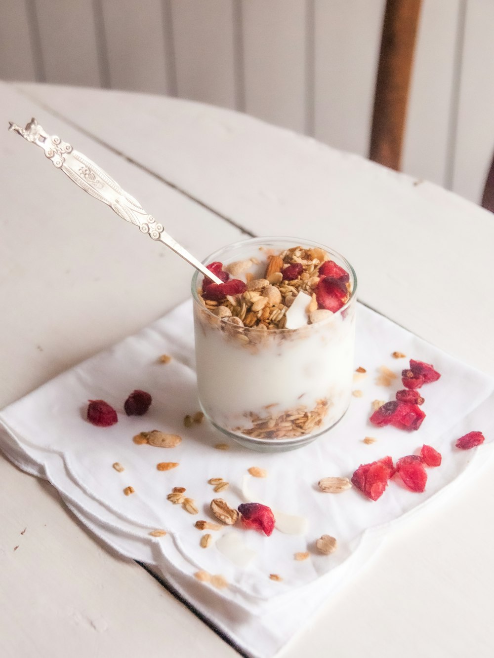 Tasse en céramique blanche et brune avec cuillère en acier inoxydable sur assiette ronde en céramique blanche