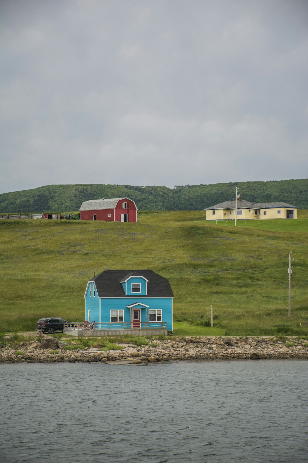 red and blue house near green grass field during daytime