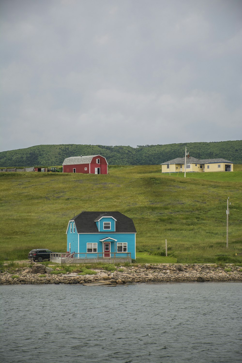 Rotes und blaues Haus in der Nähe des grünen Grasfeldes tagsüber