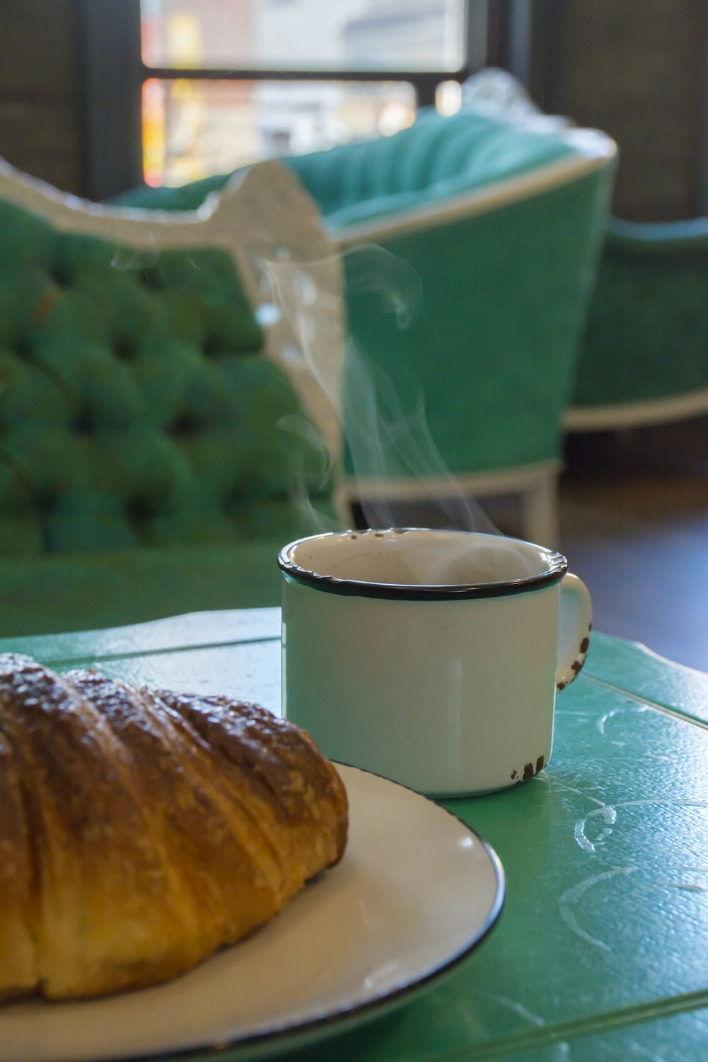 white ceramic mug beside brown bread on white ceramic plate