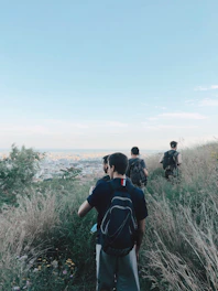 Group of travelers hiking a scenic trail with panoramic views of the city skyline.