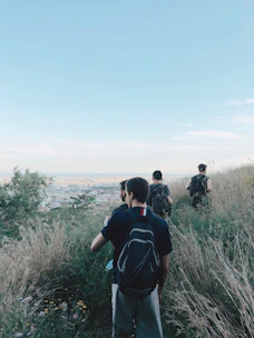 Group of travelers hiking a scenic trail with panoramic views of the city skyline.