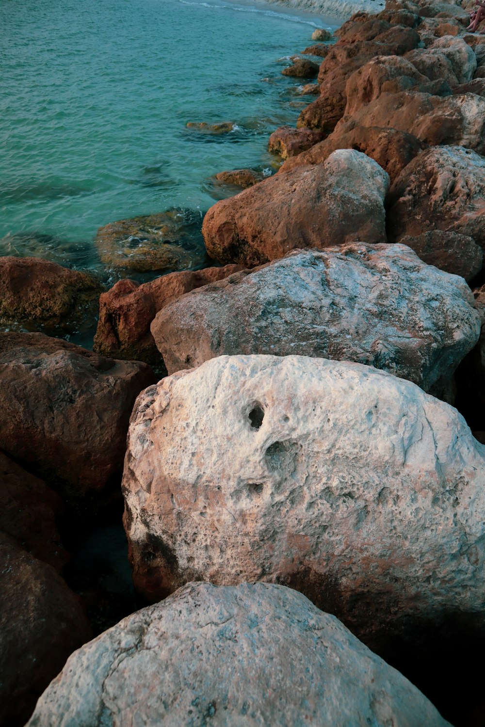 brown rock formation near body of water during daytime