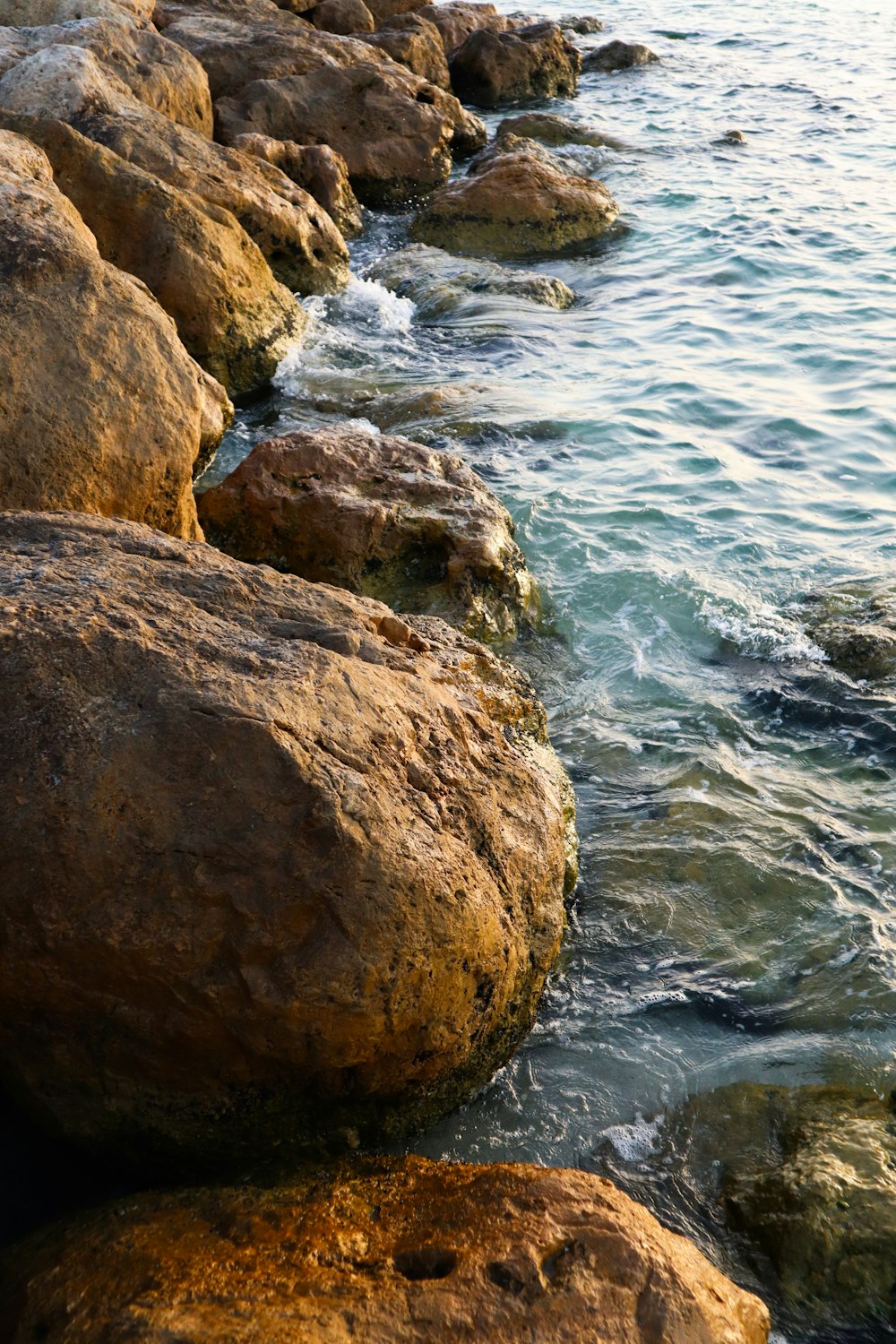 brown rock formation near body of water during daytime