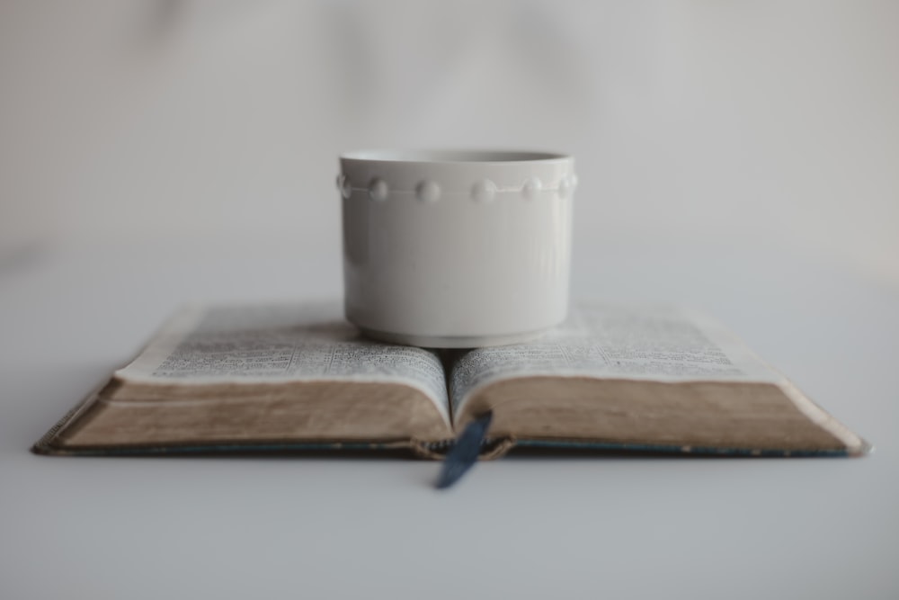white ceramic mug on book page