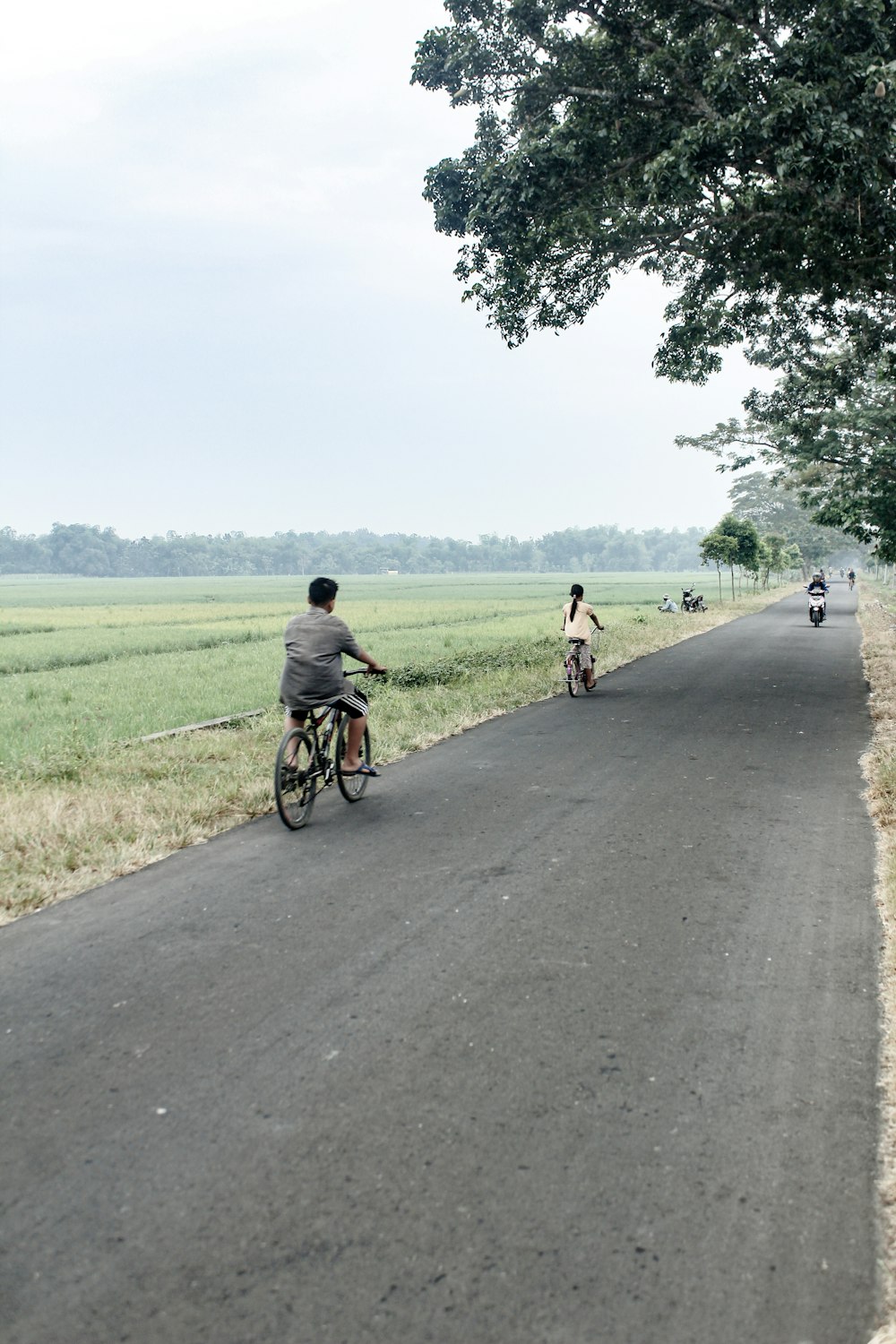 man in yellow shirt riding bicycle on road during daytime