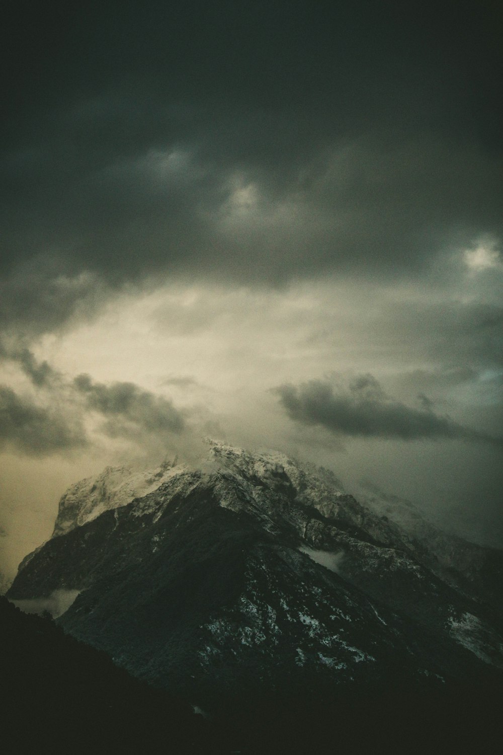 black and white mountain under white clouds