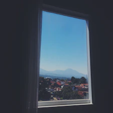 A sleek white uPVC window profile with the Himalayan mountains in the background under a clear blue sky.