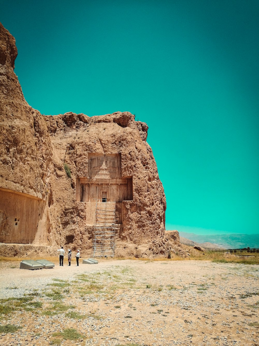 person in white shirt standing on brown rock formation during daytime