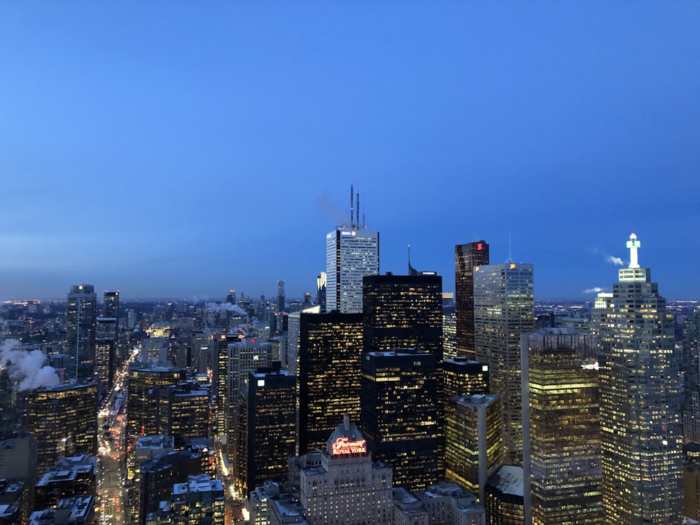 city skyline under blue sky during night time