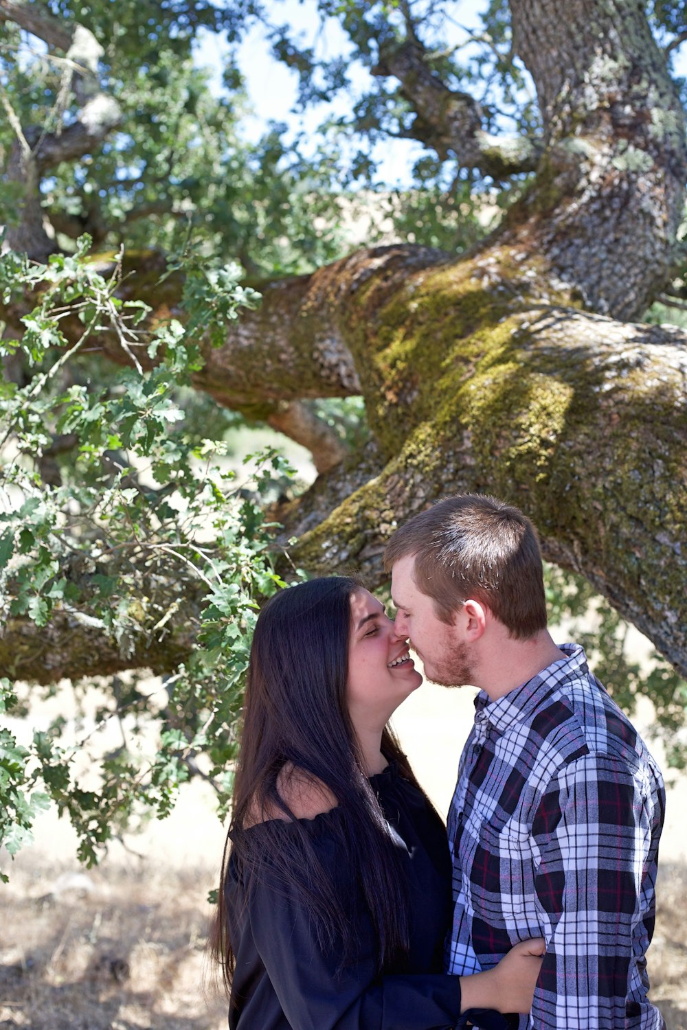 man and woman standing beside tree