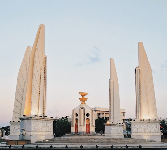 white concrete building under blue sky during daytime in Democracy Monument Thailand