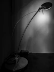 A sleek table lamp with a warm amber glow on a modern desk setup.