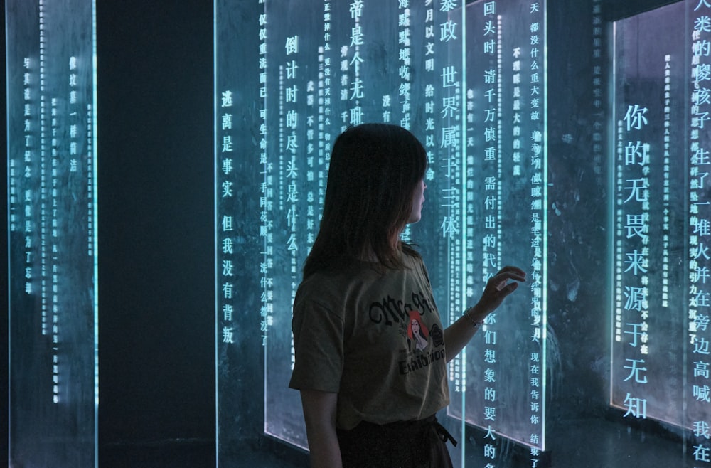 woman in gray crew neck t-shirt standing in front of blue and white string lights