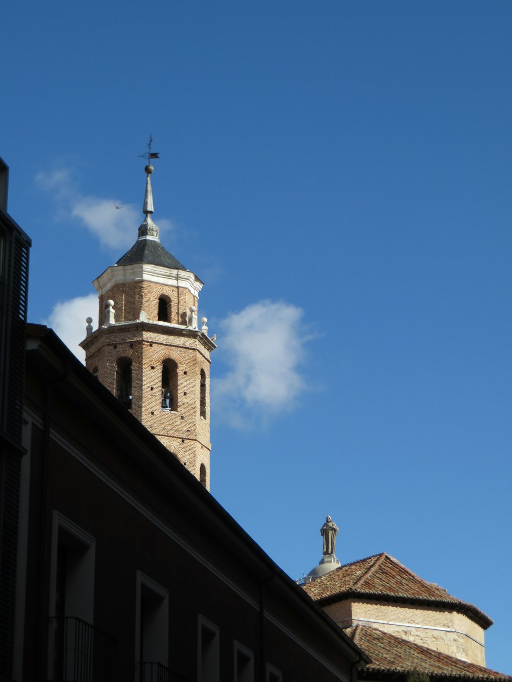 Chiesa in cemento marrone e bianco sotto il cielo blu durante il giorno