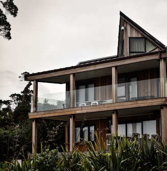 brown and white concrete building near green trees under white sky during daytime