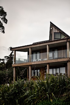 brown and white concrete building near green trees under white sky during daytime