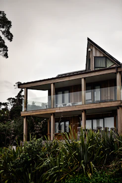 brown and white concrete building near green trees under white sky during daytime