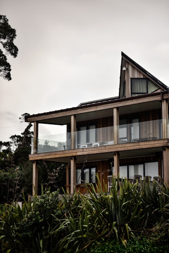 brown and white concrete building near green trees under white sky during daytime