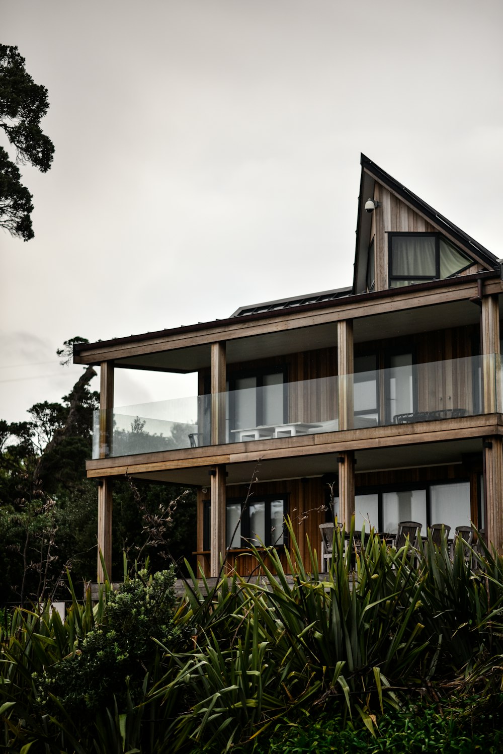 brown and white concrete building near green trees under white sky during daytime