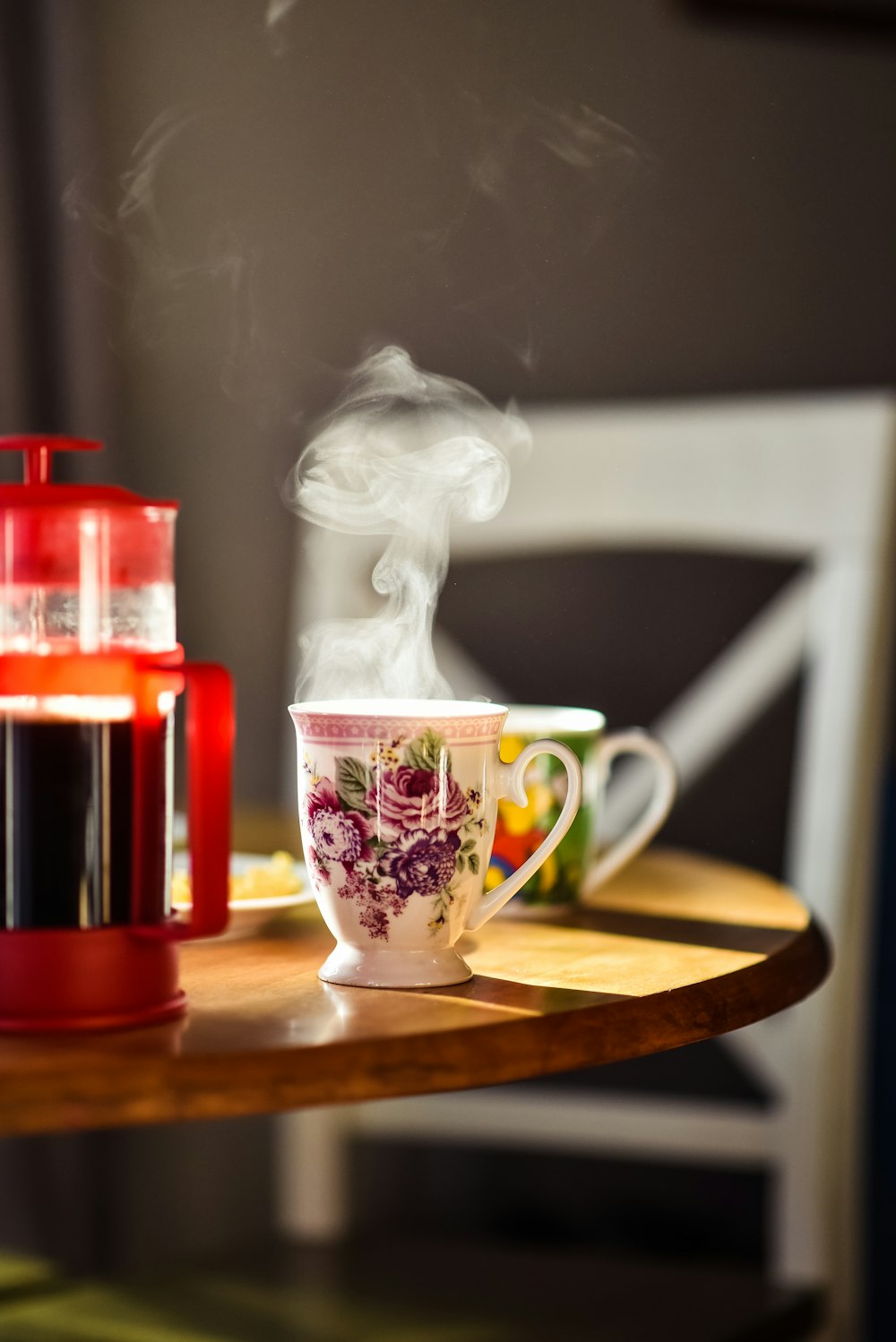 white and red floral ceramic mug on brown wooden table