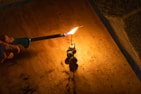 Hands lighting a firework fuse outdoors