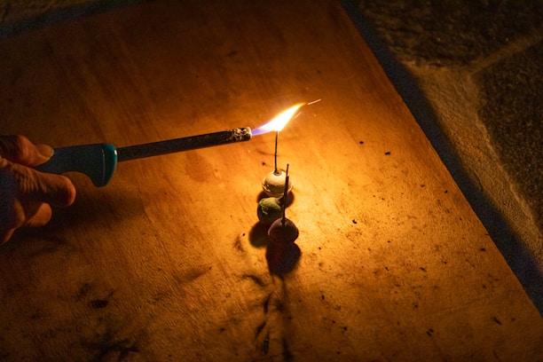 Close-up of hands carefully lighting eco-friendly green crackers with a warm glow.