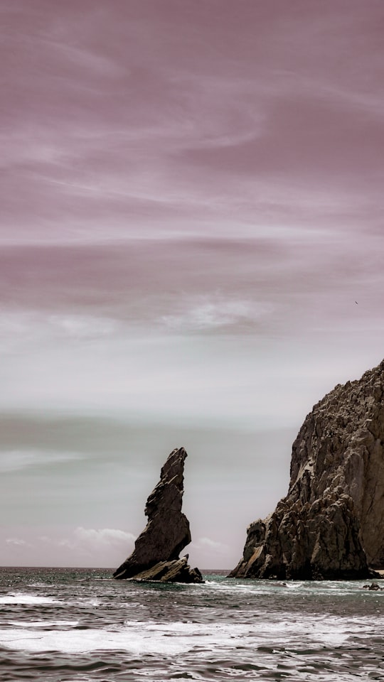 brown rocky mountain under white clouds in Cabo San Lucas Mexico