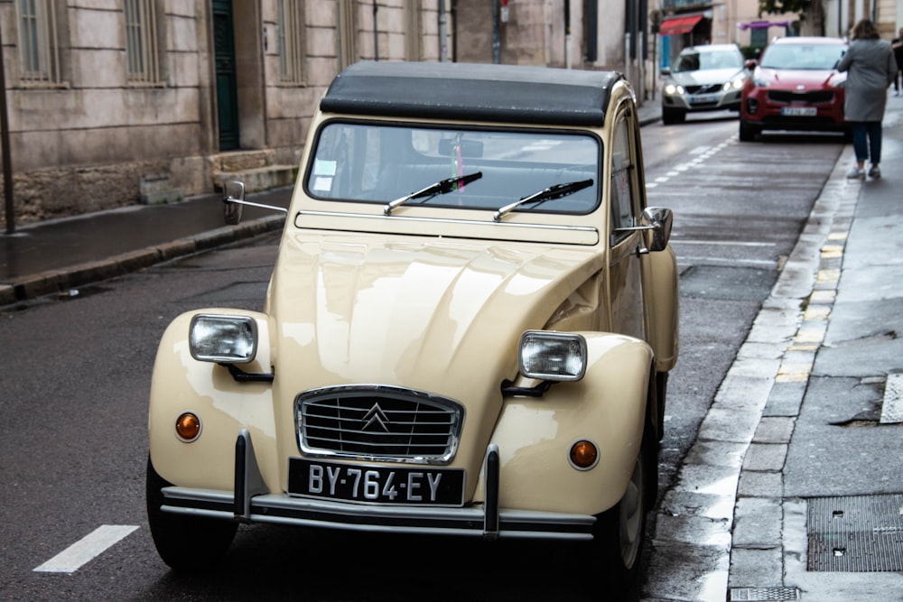 yellow volkswagen beetle parked on sidewalk during daytime