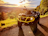 A rugged ATV with a bright yellow bumper is parked on a gravel path, facing a lush, sunlit valley. The landscape is filled with rolling green hills and scattered trees, with a vibrant sunset casting warm hues over the scene.