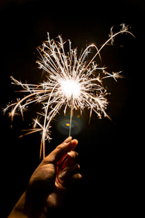 person holding white fireworks during nighttime