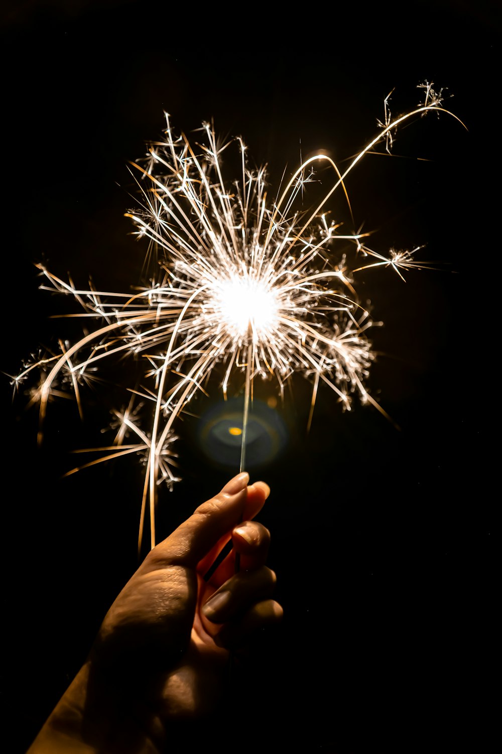 pessoa segurando fogos de artifício brancos durante a noite