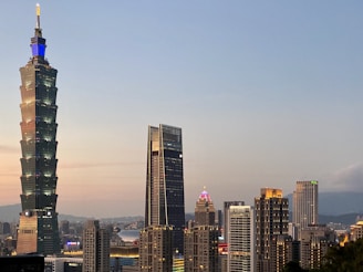 The modern skyline of Riyadh with iconic skyscrapers glowing at dusk.