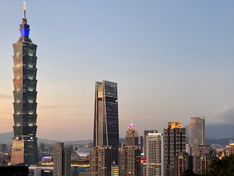 Elegant Gurugram skyline at dusk with luxury high-rise buildings glowing warmly.