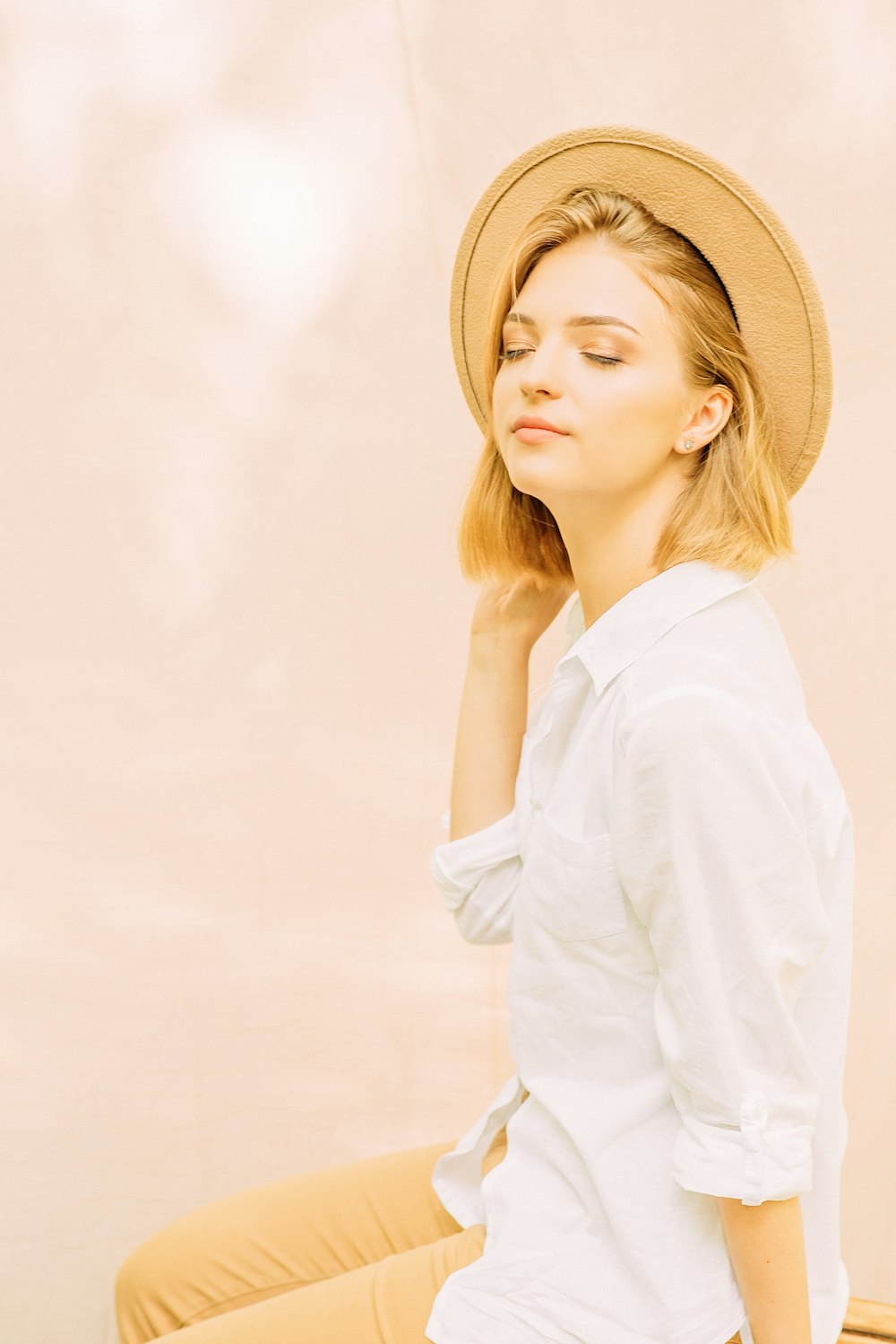 woman in white long sleeve shirt wearing brown hat