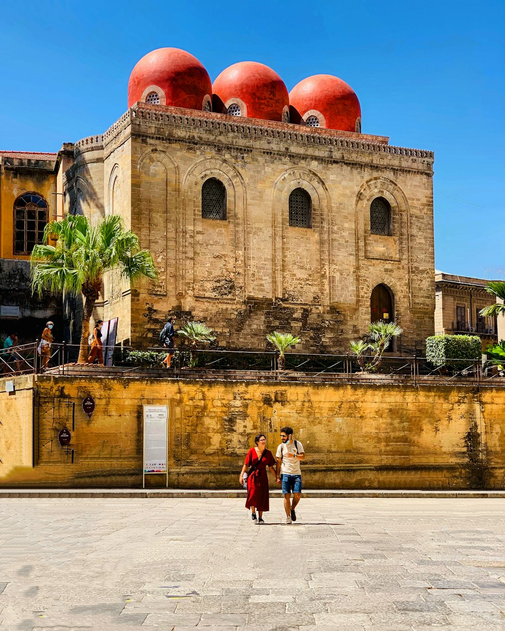 2 women standing near brown concrete building during daytime