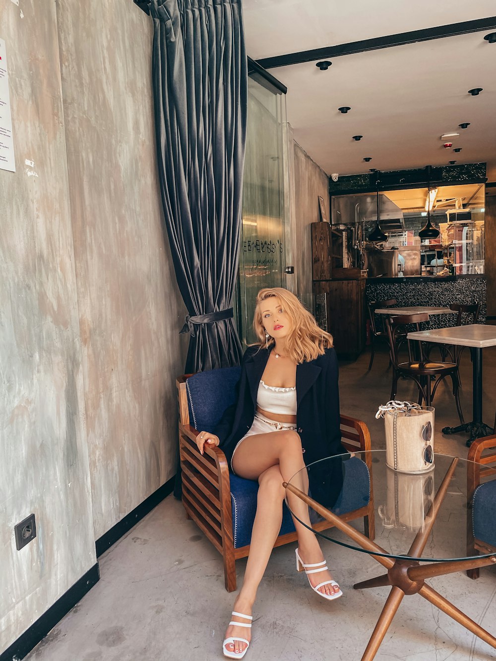 woman in black tank top sitting on brown wooden chair