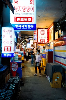 man in yellow t-shirt walking on street during nighttime