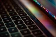 Close-up of a high-end laptop keyboard with a subtle reflection of a brand logo.