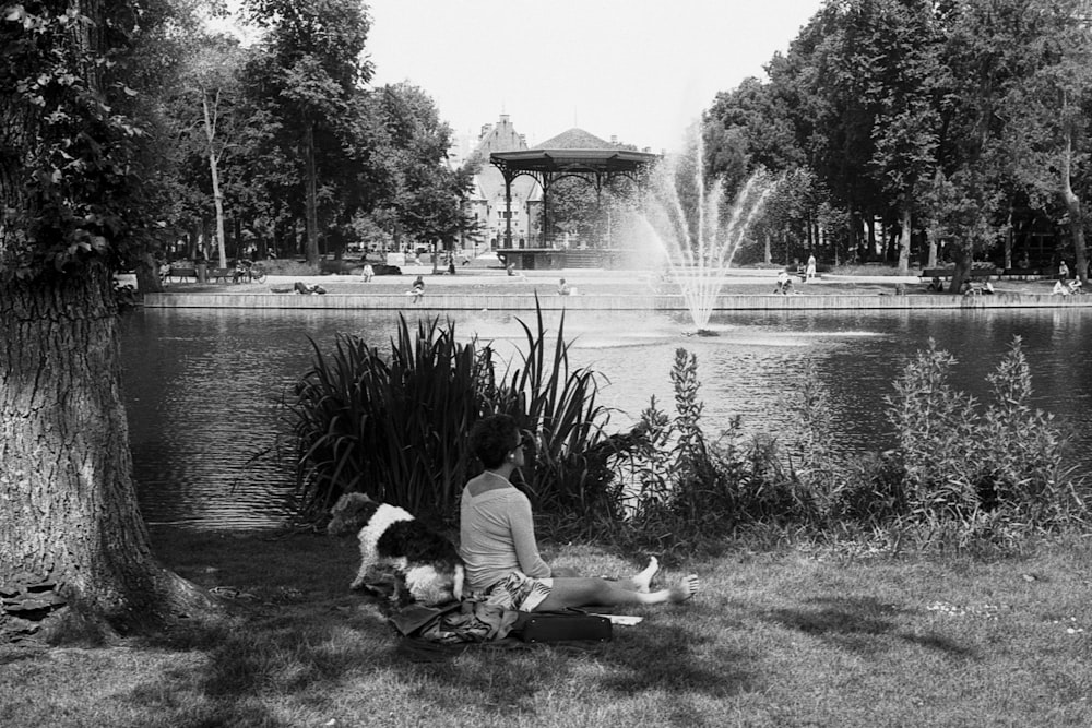 man sitting on bench near water fountain