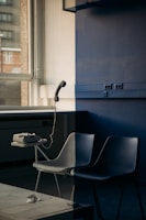 white and black chair beside blue wall