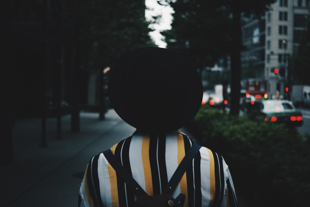 person in black and white striped shirt wearing black hat